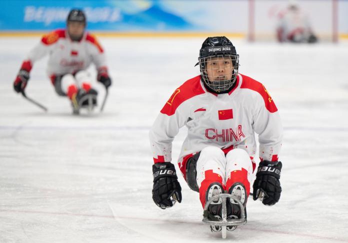 A Chinese female Para ice hockey player is on the ice during Beijing 2022 Paralympic Games.