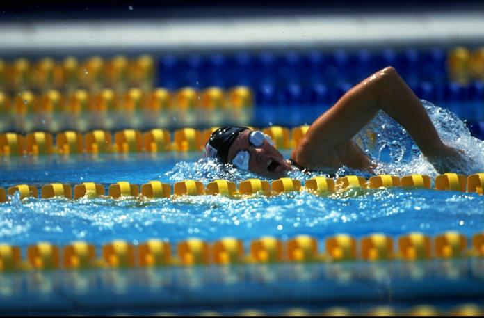 A woman takes a breath as she competes in a freestyle swimming race at Barcelona 1992.