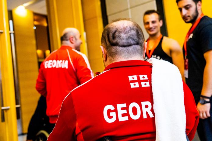 Men in Georgian uniforms greet each other during a training session.