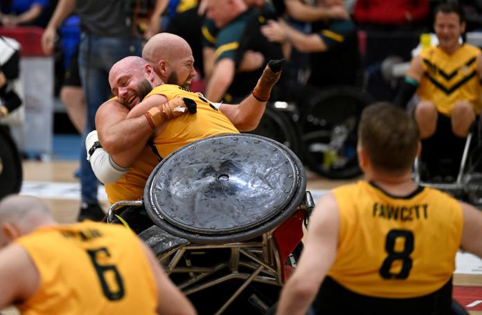 Two wheelchair rugby players hug to celebrate their win