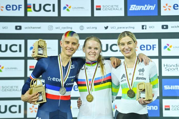 Three female Para cyclists pose with their medals on the podium.