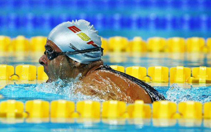 A side view of a male athlete swimming