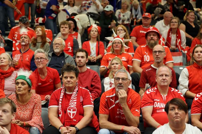 People dressed in red fill the stands at a venue.