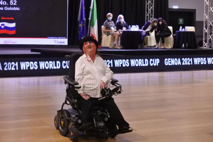 A female dancer in an electric wheelchair, wearing a Charlie Chaplin style costume, performs in a dance competition.