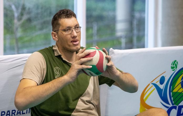 A male athlete holds a ball in front of his chest