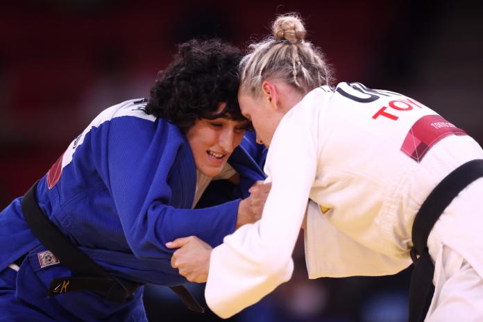 Two female judokas grapple on the mat during a Paralympic Games final.