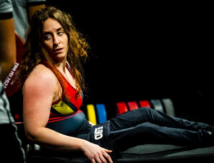 A female Para powerlifter looks back at the barbell as she prepares to make a lift.