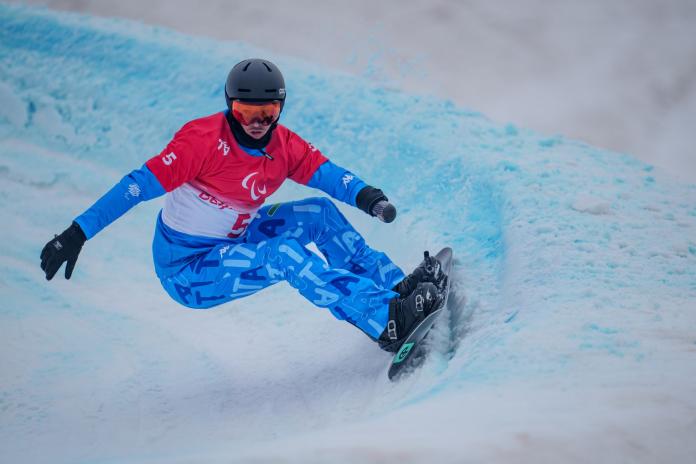 A male snowboarder competes at Beijing 2022 Paralympic Games.