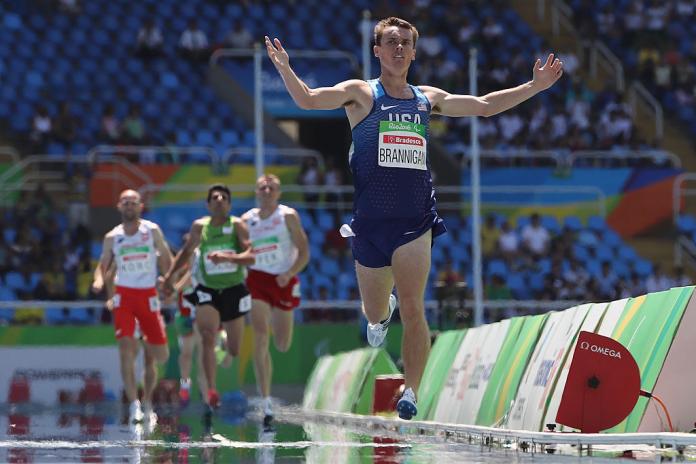 A male athlete runs ahead of three other athletes at Rio 2016.