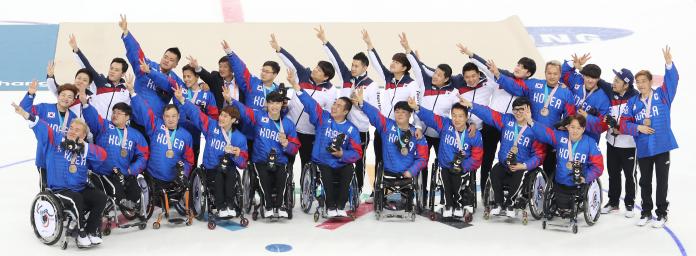 Twenty-seven athletes and team staff wearing the Republic of Korea jersey pose for a photograph together.