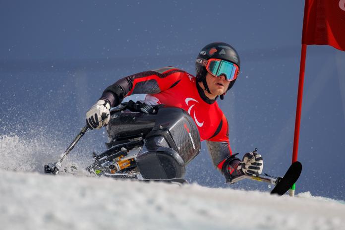 A male athlete competes on a sit-ski.