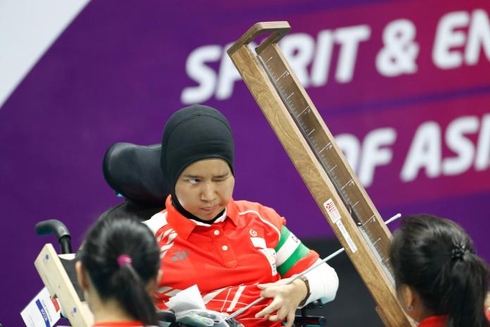A female athlete looks at the ramp she uses to deliver the ball during a boccia match.