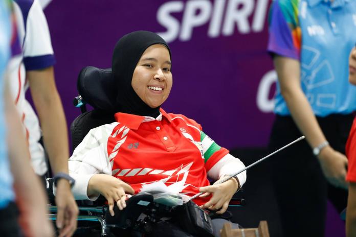 A female boccia athlete smiles during competition
