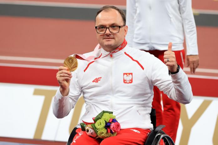 Sportowiec pozuje do zdjęcia po otrzymaniu złotego medalu na Igrzyskach Paraolimpijskich w Tokio w 2020 r.