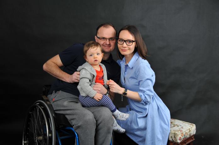 A family photo of a male athlete, his wife and son.