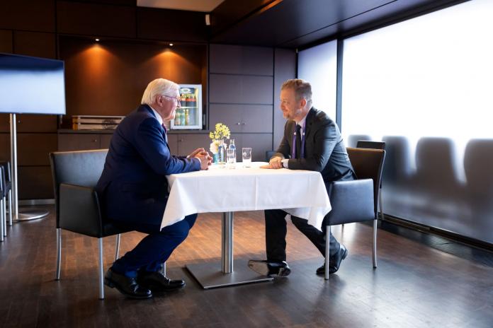 Two men sit at a table.