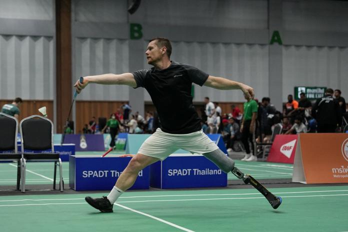 A male athlete wearing a prosthetic blade plays badminton.