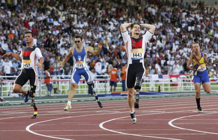 Four male athletes with blades competing on the track