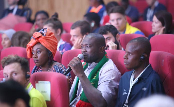 A male representative makes a comment at an auditorium.