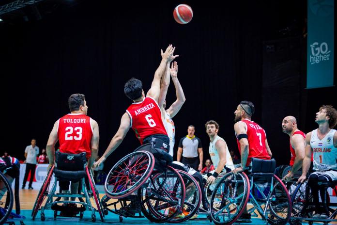 Male wheelchair basketball players play a game.