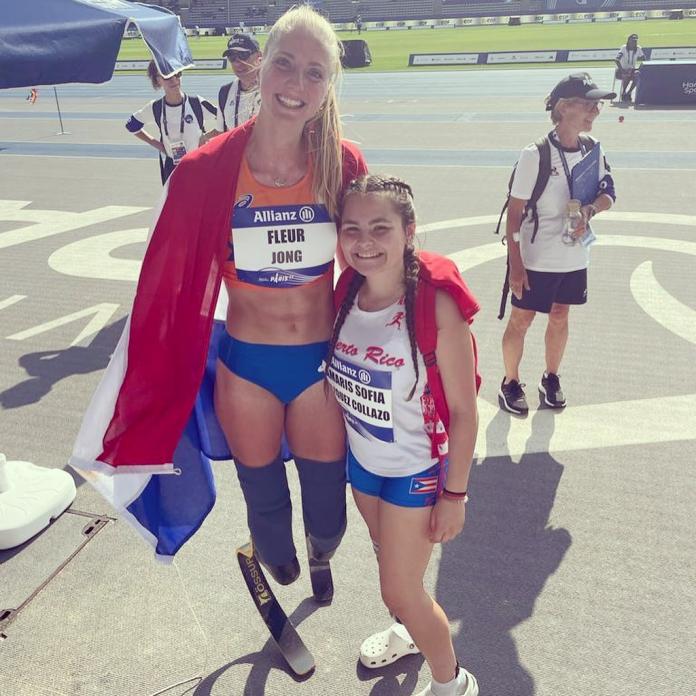 Two female athletes pose for a photograph