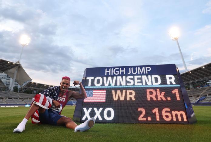 Roderick Townsend-Roberts sitting next to the board showing his world record 2.16m