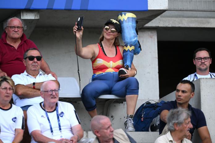 a female spectator taking a selfie with her prosthetic leg 