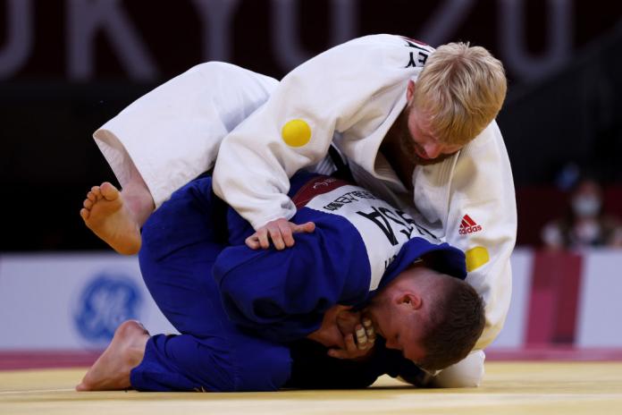 Two male judokas fighting on the mat