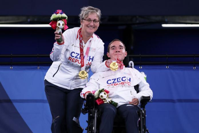 Adam Peska and Ivana Peskova smiling with their gold medals 