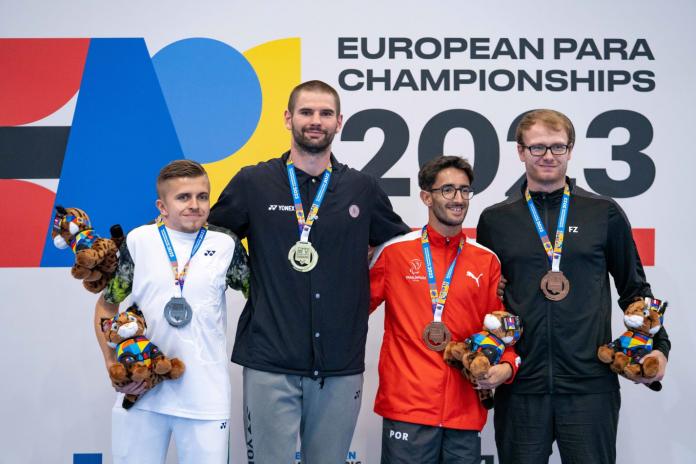 Four male athletes pose for a photo after receiving their medals.