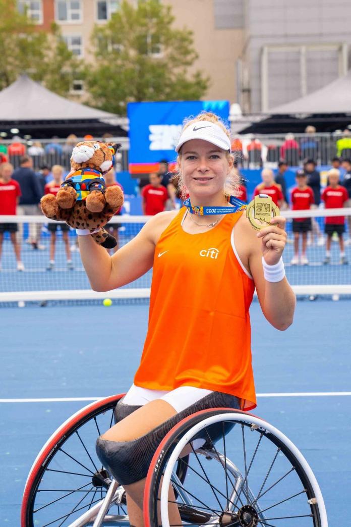 Diede de Groot holding up a gold medal and a mascot