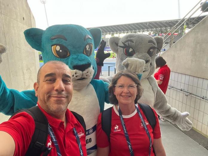 two people taking a selfie with two mascots 