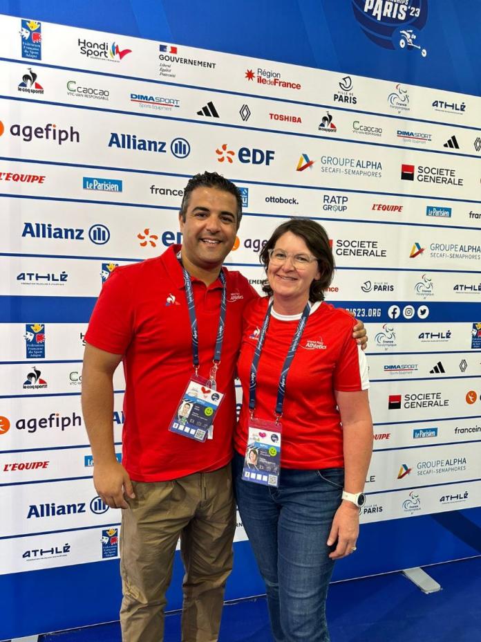 Two people standing in front of a mixed zone board