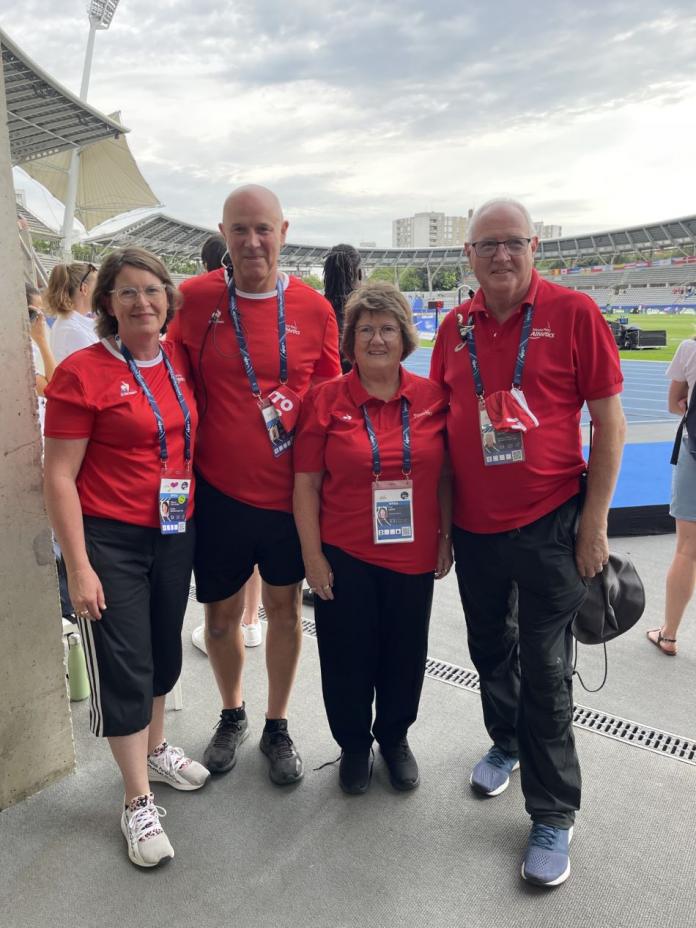 four people standing together in a stadium 