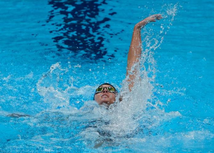 A female swimmer competing in backstroke
