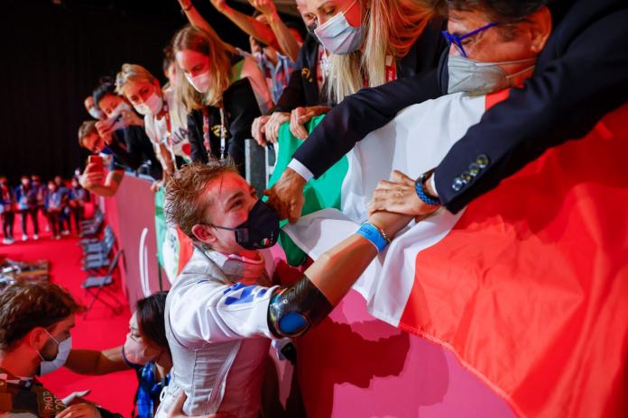 A female athlete celebrates with people in the stands