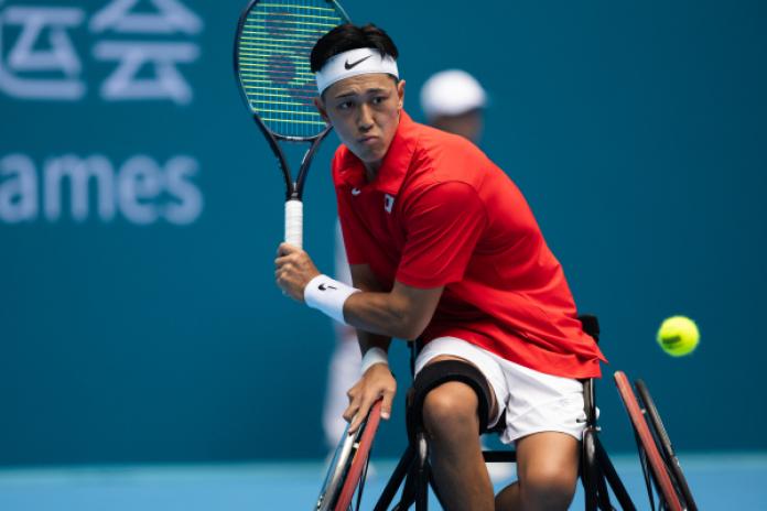 A male wheelchair tennis athlete competes