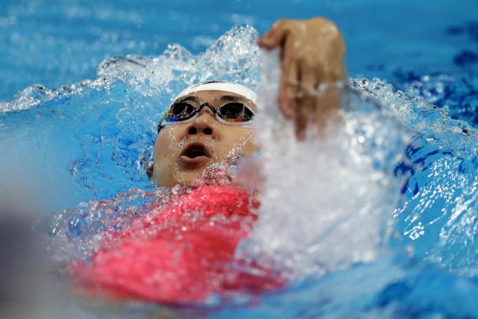 A female swimmer competing in backstroke