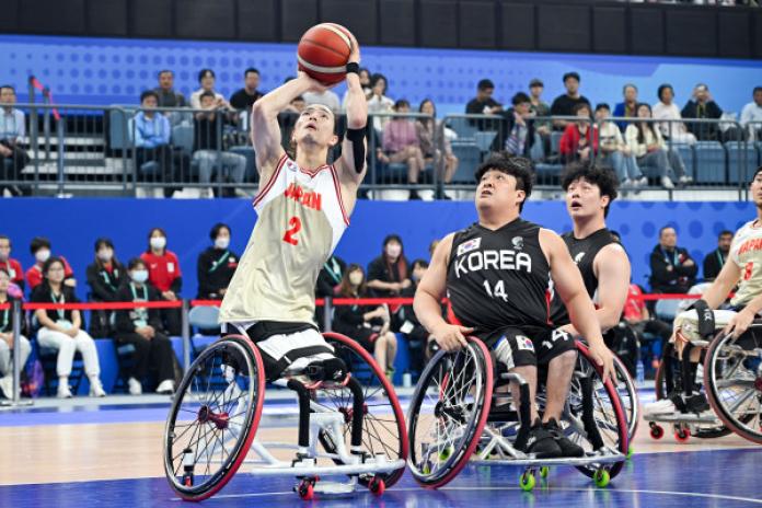 A male athlete attempts a shoot during a wheelchair basketball match