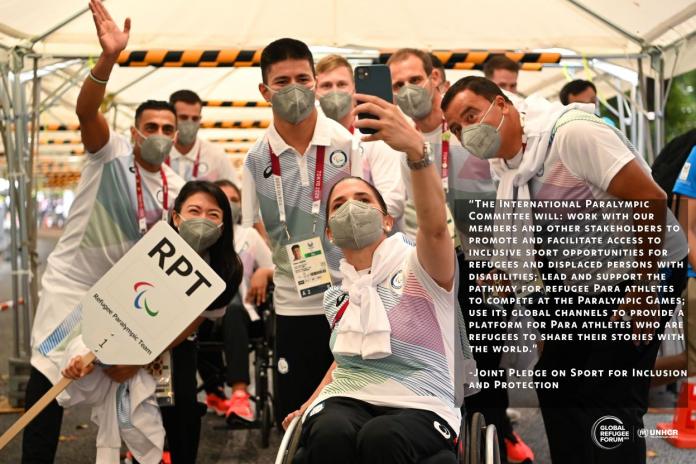 A photo of the Refugee  Paralympic Team at Tokyo 2020 taking a selfie. There is a text of the joint pledge on sport for inclusion and protection next to it.