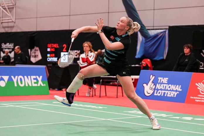 A female Para badminton player competes in a tournament.