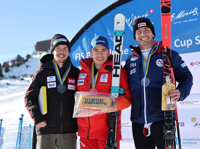Three skiers pose on a podium. 