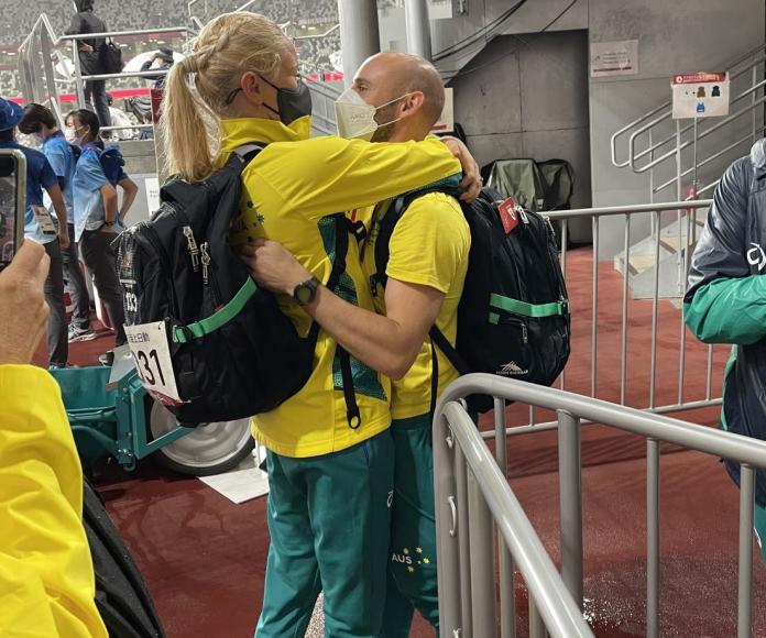 A female athlete and a male athlete hug at the Tokyo 2020 Games.