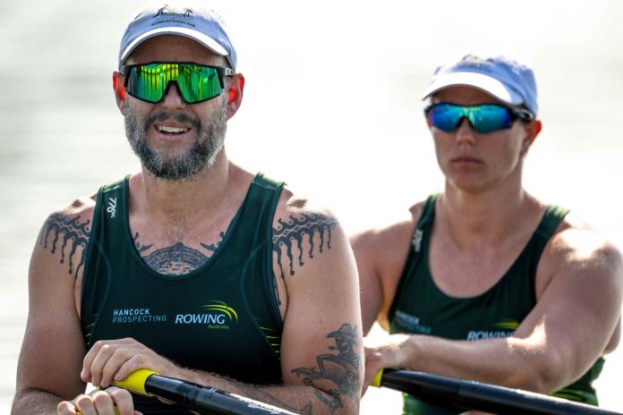 Two Para rowers - a male athlete and a female athlete - are sitting on a boat.