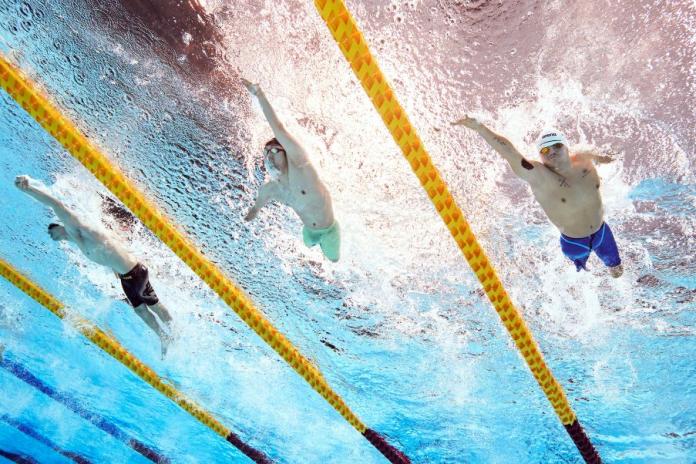 An underwater photo of three Para swimmers competing