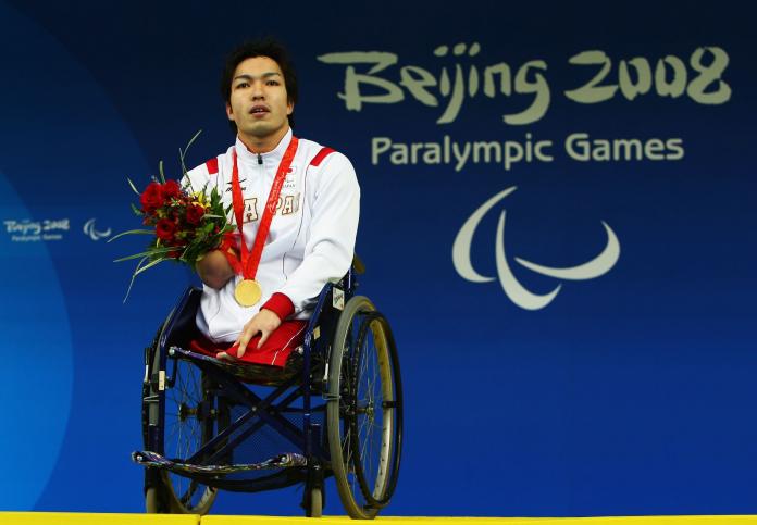 A male athlete poses for a photograph after receiving a gold medal at the Beijing 2008 Paralympics.