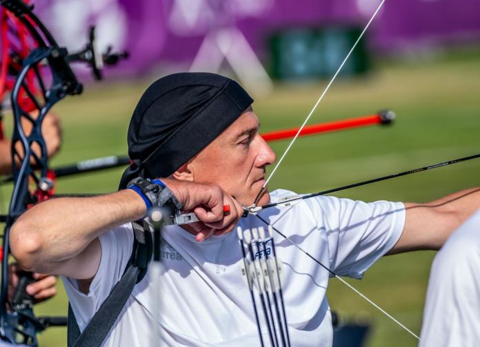 A male Para archer shoots an arrow during competition.