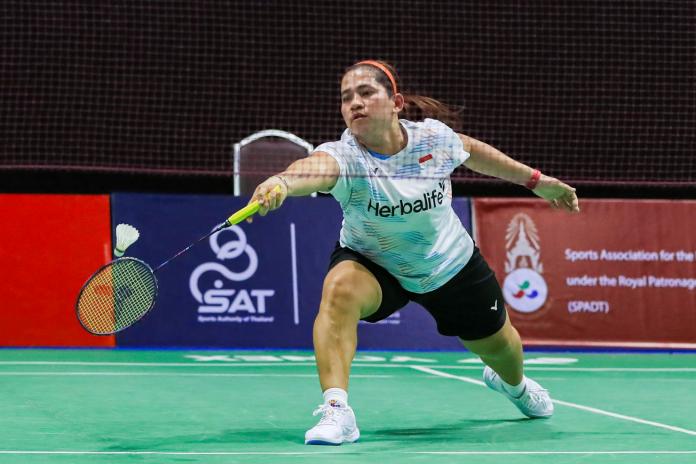 A female Para badminton player reaches for the shuttle during a Para badminton match