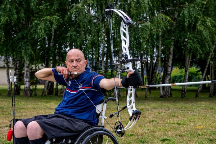 A male Para archer aims for a target.