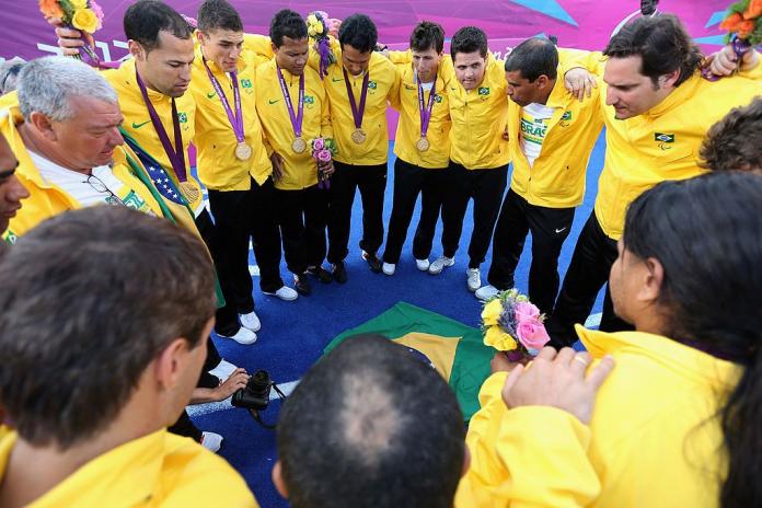 Blind football players and staff form a circle after receiving their gold medals at the London 2012 Games.